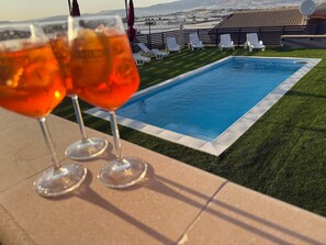 A swimming pool with lounge chairs and a view of distant hills. - Villa "Nicolai - First Floor" with Mountain View, Shared Pool, and Private Terrace (Licata)