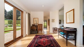 A spacious hallway with a large window, a patterned rug, wooden furniture, and framed artwork on the walls. - Pet Friendly - Shoreham Homestead Walk to Vineyards (Shoreham)
