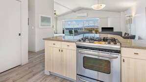 A modern kitchen with a large island, stainless steel appliances, and pendant lighting. - Modern Condo W/Ocean Views and Lanai - Waikīkī Shore #ph07 (HONOLULU)