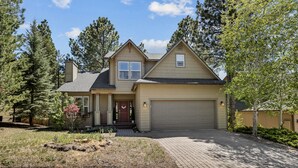 A two-story house with a garage, surrounded by trees and a landscaped yard. - Modern Cabin Minutes to Flagstaff! Trailside Retreat w/ Trails/Park & 2 Car Garage (Flagstaff)