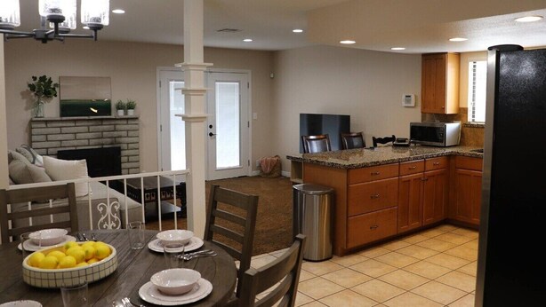 A modern kitchen with wooden cabinets, a built-in microwave, and a stainless steel refrigerator. - Brand new floors in sunny Las Vegas! (Las Vegas)
