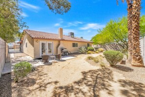 A residential property with a patio, outdoor furniture, and a variety of plants.