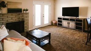 A living room with a fireplace, sofa, coffee table, TV, and entertainment unit. - Brand new floors in sunny Las Vegas! (Las Vegas)