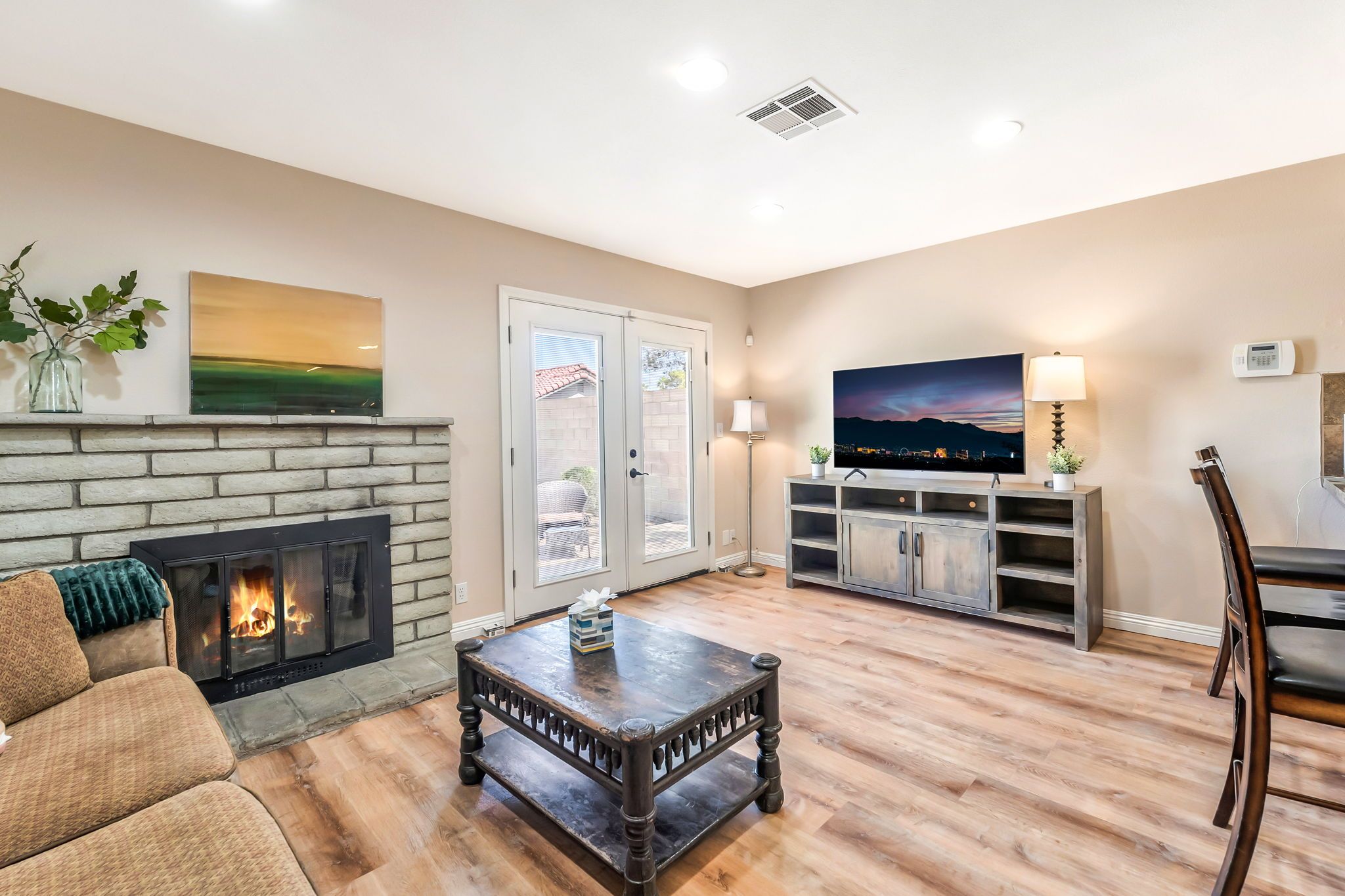 A living room with a fireplace, a television, and a dining area.