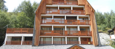 Un edificio de madera de varios pisos con balcones, un letrero que dice