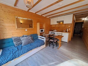A compact room with a bed, a dining table, and a kitchenette. - Cozy studio with south balcony, pets allowed, near slopes (Les Deux Alpes)