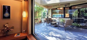 Un intérieur moderne comprenant un coin salon, une grande fenêtre et une œuvre d’art accrochée au mur.