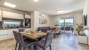 Une cuisine moderne avec un coin repas, un canapé et un balcon offrant une vue agréable.