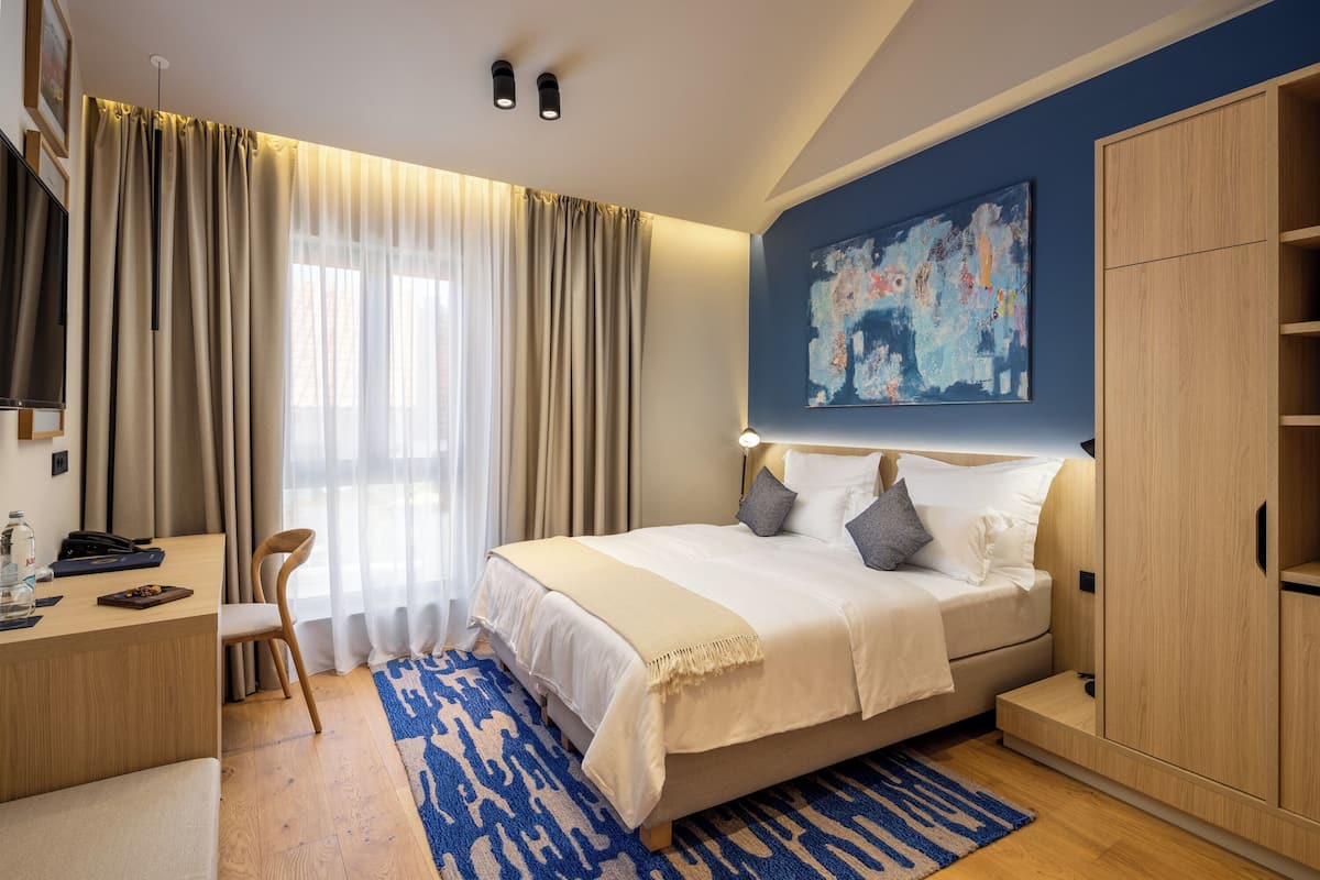 Une chambre d’hôtel moderne équipée d’un lit, d’un bureau et d’une armoire.