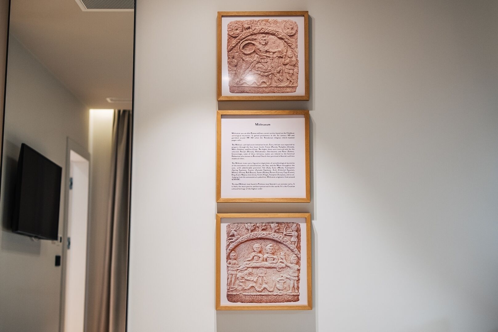 Un pasillo decorado con cuadros enmarcados y placas informativas en la pared.