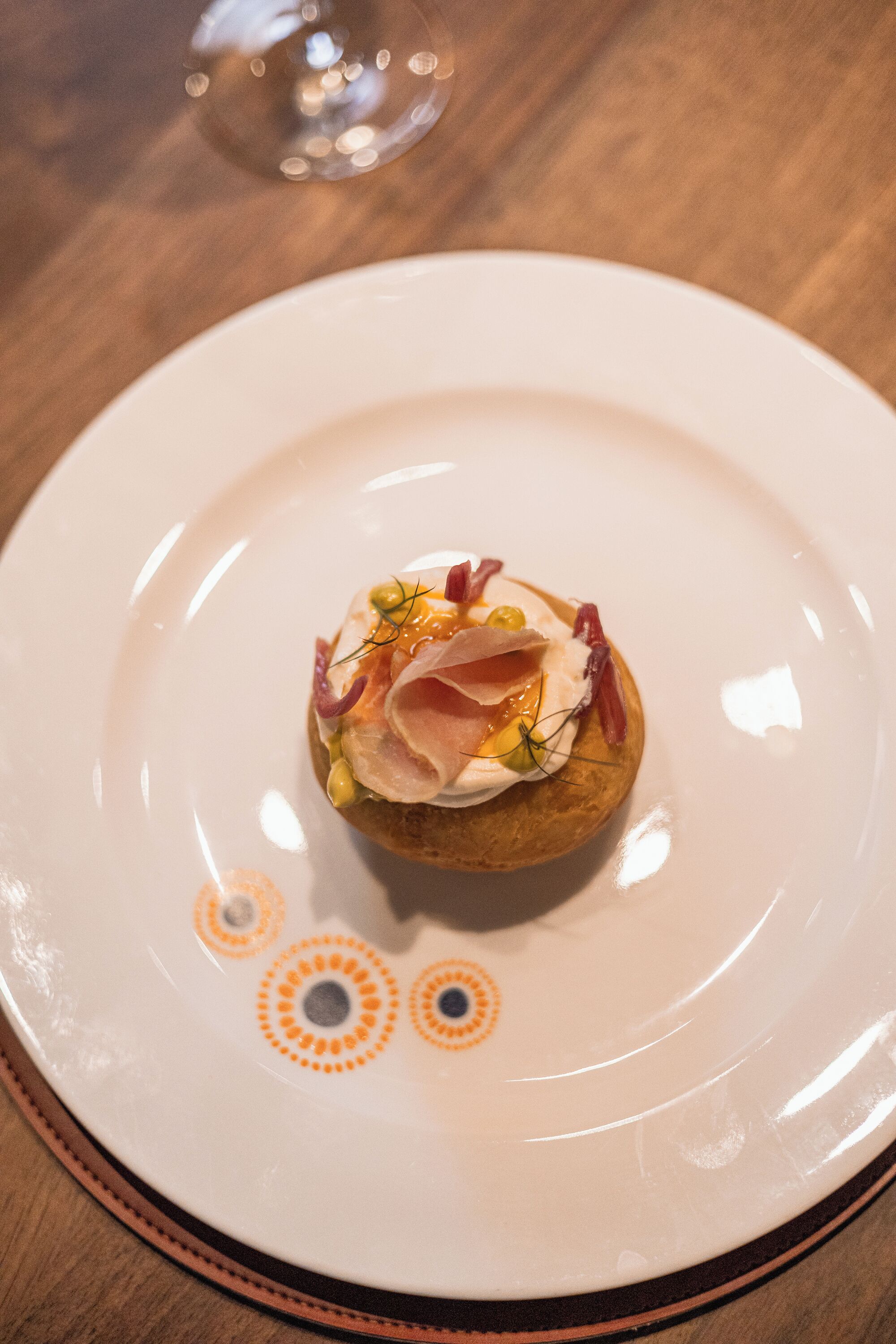 A dessert on a white plate with orange and gray decorative patterns.