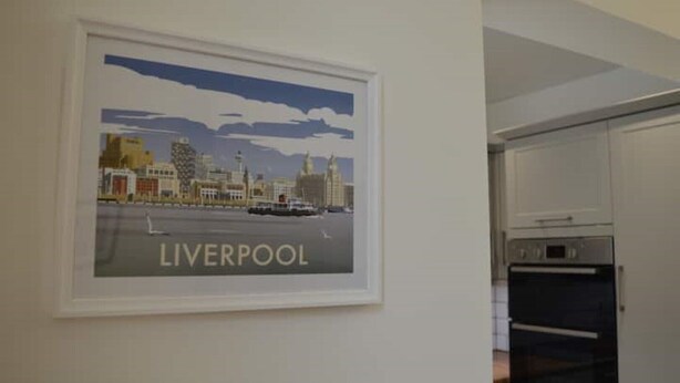 Un poster incorniciato con una veduta di Liverpool su una parete, con una zona cucina visibile a destra.