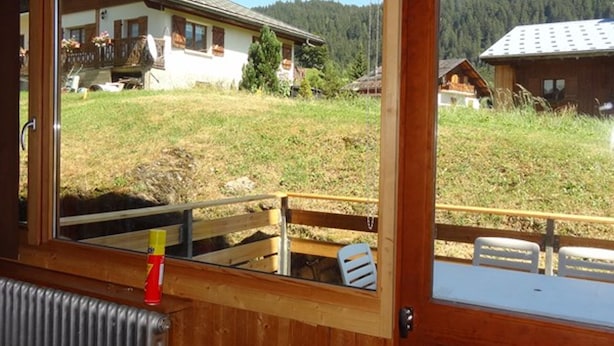 A wooden cabin with a view of a house and forested hills. - Central Apartment for 5, Near Slopes & Shops, Crest-Voland (Crest-Voland)