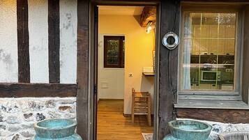 A wooden door leading into a room with a window and a small table.