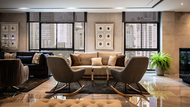 A modern living room with a sofa, two rocking chairs, a coffee table, and a potted plant. - SAM E Hotel Bangkok Sathorn (Bangkok)