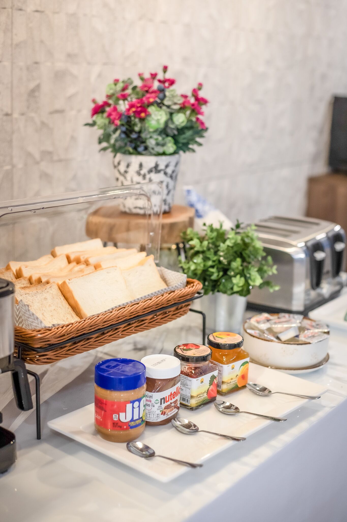 A breakfast buffet with bread, peanut butter, and jam.