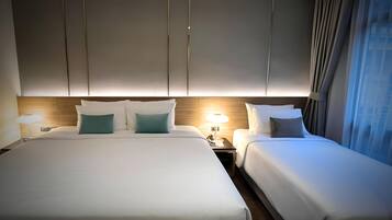 Et hotelværelse med to senge, et træhovedgærde og et natbord med en lampe.