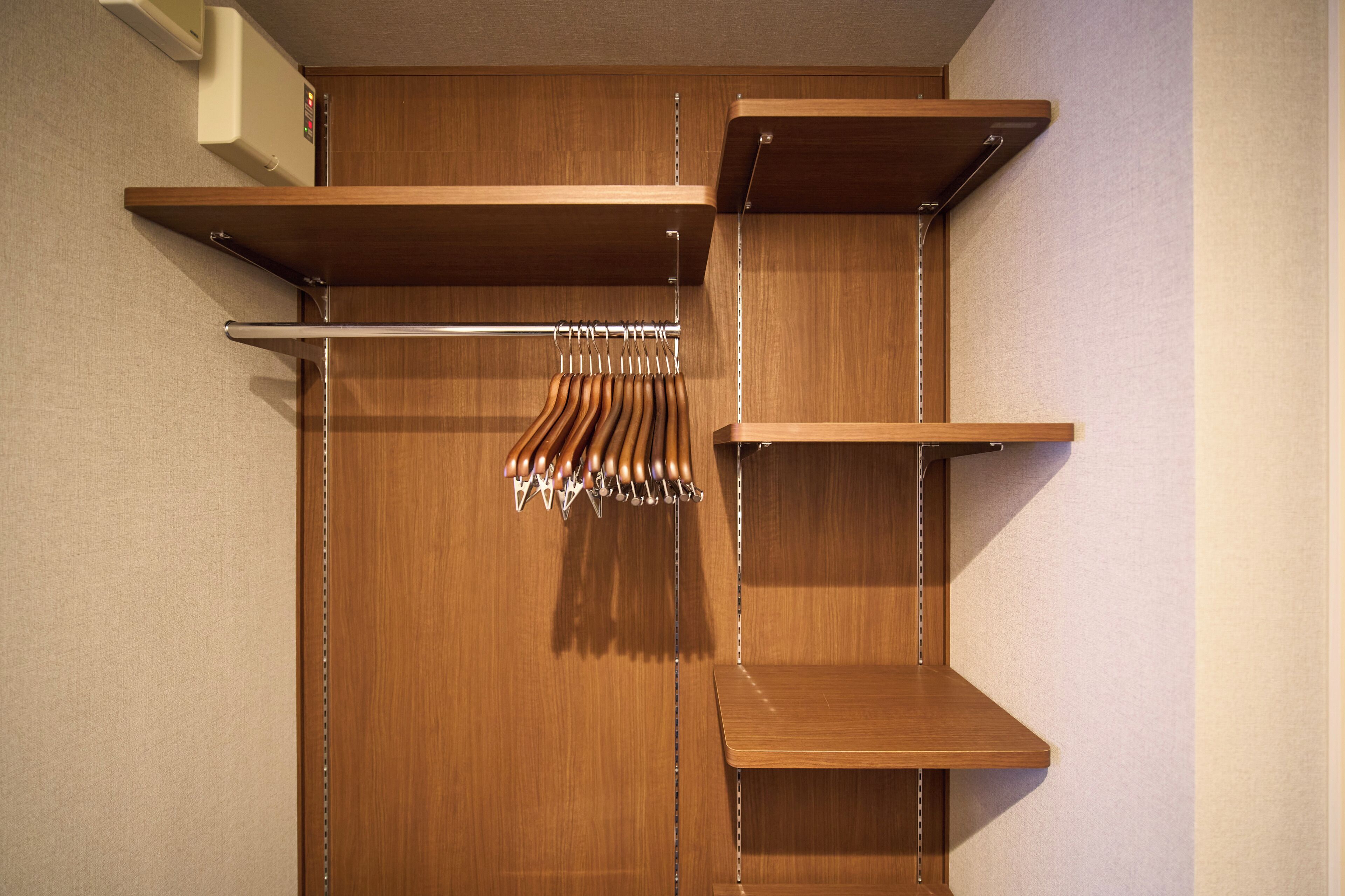 A wooden closet with shelves and a hanging rod.