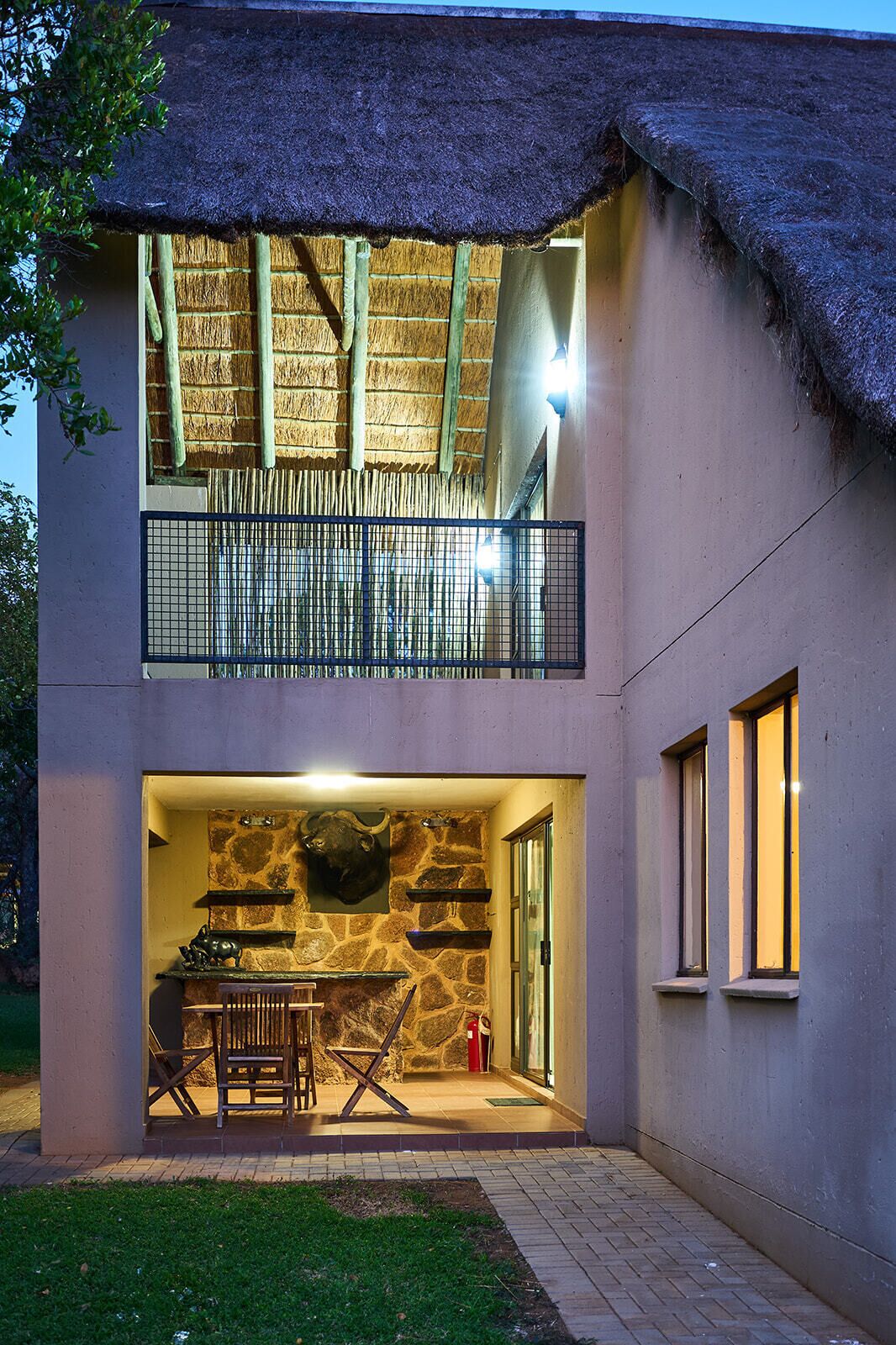 A two-story building with a thatched roof balcony, a stone wall interior, and a fire extinguisher visible.