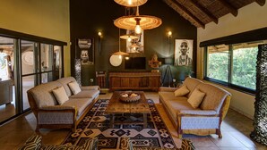 A room with two sofas, a coffee table, and hanging lamps.