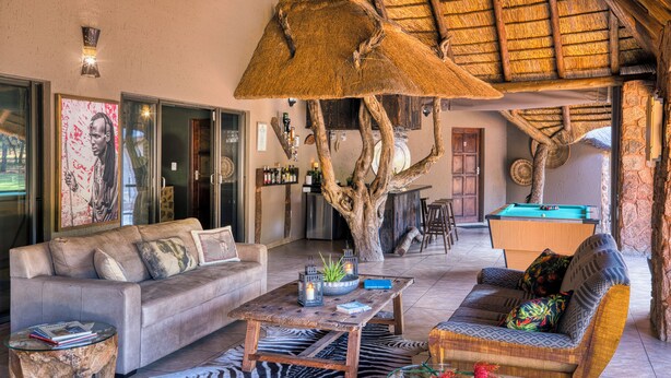 A spacious living area with a sofa, a coffee table, and a pool table.