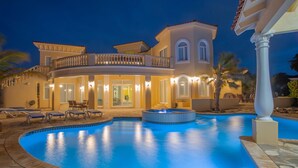 A luxurious villa with a swimming pool, outdoor seating, and a well-lit entrance. - This One of a Kind Amazing Aruba Beach House (Noord)