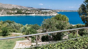 A coastal landscape with a clear blue sea, rocky terrain, and scattered buildings. - Chloe Seafront Villa (Chania)