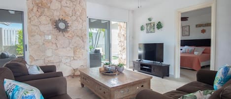 A living room with stone walls, a television, and a sofa.
