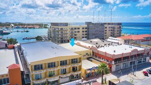 A coastal hotel with multiple floors, balconies, and a view of the marina and ocean. - NEW Bay Harbor Studio 203 (Oranjestad)
