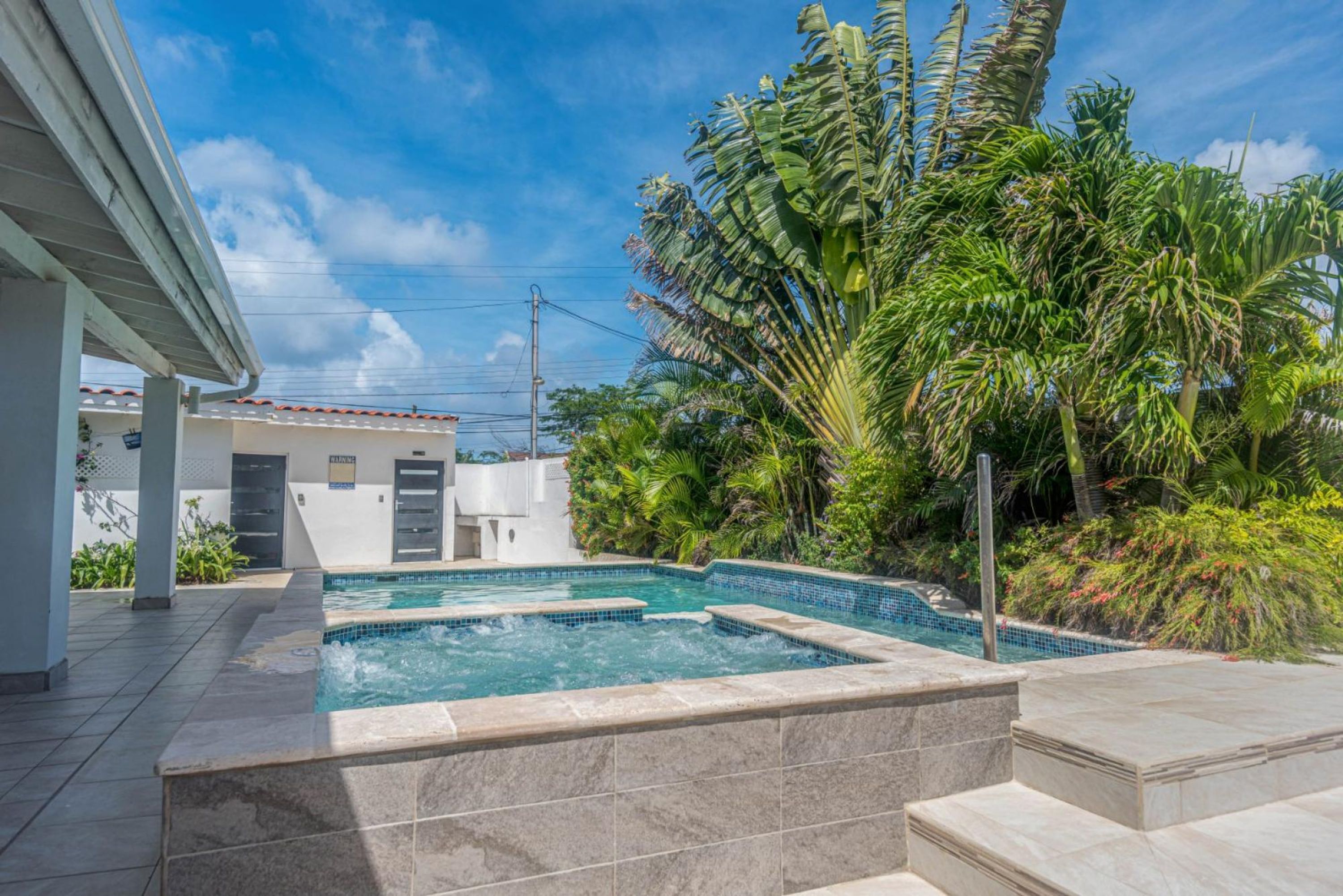A swimming pool with a tiled deck and a small waterfall feature.