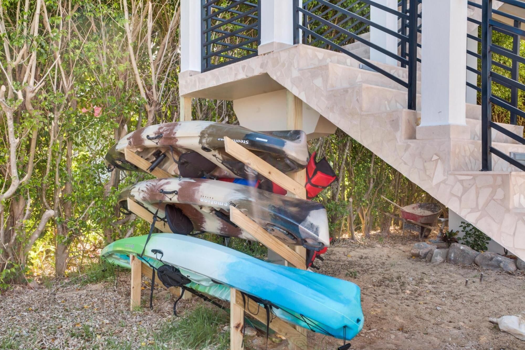 A staircase leading to a building with kayaks stacked against it.