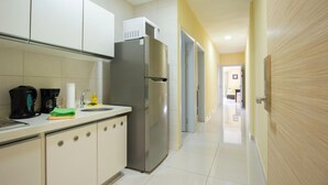 A modern kitchen with a stainless steel refrigerator, a coffee maker, and a sink.