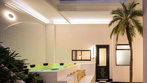 A modern bathroom with a large bathtub, a palm tree, and a checkered floor. - Holt Hotel De Mi Independencia (Oaxaca)