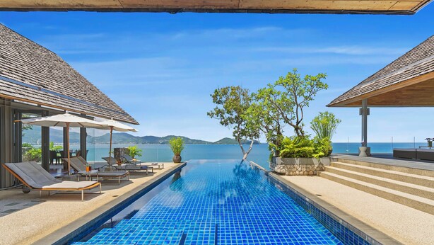Ein Infinity-Pool mit freiem Blick auf das Meer, Liegestühle und Kübelpflanzen.