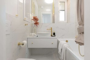 Bathtub, hair dryer, towels, shampoo