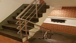 A staircase with metal handrails and a brick wall. - MeroStay 179 Shree (Kathmandu)