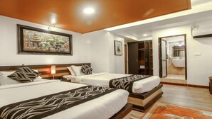 A hotel room with two beds, a large painting on the wall, a wardrobe, and a bathroom visible through an open door. - MeroStay 179 Shree (Kathmandu)