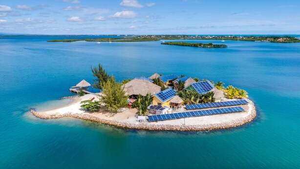 A tropical island resort with thatched-roof huts, solar panels, and a beach. - Exclusive Private Island With 360 Degree View of the Ocean (Placencia)