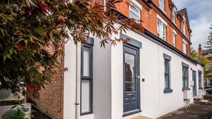 A modern two-story house with a white exterior and dark blue trim. - Modern, Stylish 1 Bedroomed Apartment (Nottingham)
