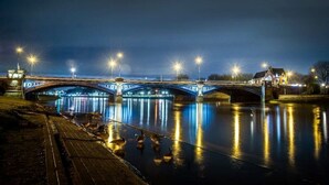 A nighttime view of a bridge with illuminated lights reflecting on the water. - Modern, Stylish 1 Bedroomed Apartment (Nottingham)
