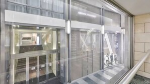 Moderni rakennus, jossa on lasijulkisivu, selkeästi näkyvä sisäänkäynti ja kyltti, jossa lukee ”ARMANI EXCHANGE”.