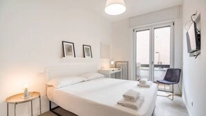 A hotel room with a bed, a small bedside table, a chair, and a balcony with a view. - Apartment in Milan with 4 bedrooms sleeps 7 (Milan)