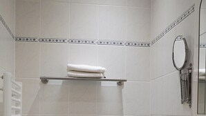 A bathroom with a toilet, a sink, a towel rack, and a mirror.