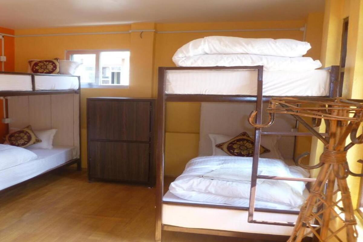 Ein Schlafraum mit Etagenbetten, einem Kleiderschrank und einem Fenster.