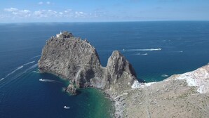 Un paysage côtier caractérisé par des falaises rocheuses et des eaux d’un bleu limpide.