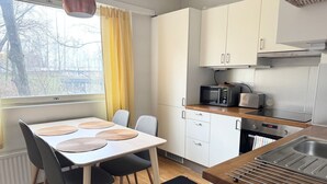 Une cuisine moderne équipée d’une table à manger, de chaises, d’un four à micro-ondes et d’un évier.