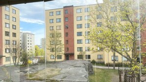 Une vue d’une cour intérieure avec des bâtiments, des arbres et une structure en pierre.