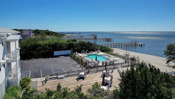 Ein Resort mit Schwimmbad, Strand und einer anlegenden Pier.