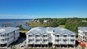Ein Küstenhotel mit mehreren weißen Gebäuden, einem Steg und Blick auf das Meer.