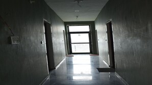 A hallway with a large window at the end, leading to an outdoor area. - Great View Hotel And Restaurant (Tehri)